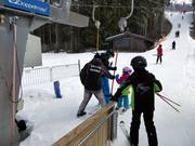 Personeel reikt beugel aan bij de sleeplift