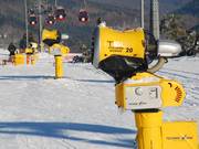 De sneeuwkanonnen staan bijzonder dicht langs de piste naast de kabelbaan.