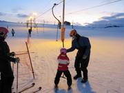 Het personeel helpt kinderen bij het instappen.