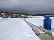 Beginnerspiste met transportband bij het dalstation van de gondelbaan