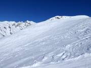 Brede poedersneeuwhellingen naast de pistes